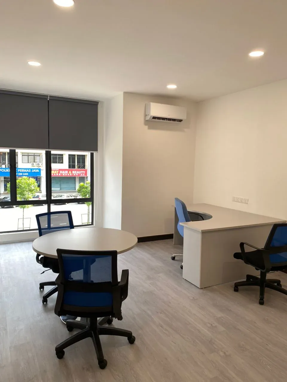 Private office with round table and desk by the window at Godori Office Permas Jaya